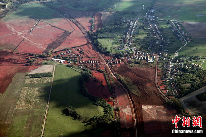 An aerial view shows flooded town of Devecser, 150 km (93 miles) west of Hungarian capital Budapest on October 7, 2010. Wave of toxic red mud swept through the small village five days ago, killing seven and injuring scores more. Red sludge flowed into the Danube River on Oct. 7, threatening a half-dozen nations along one of Europe&apos;s key waterways.[Chinanews.com]