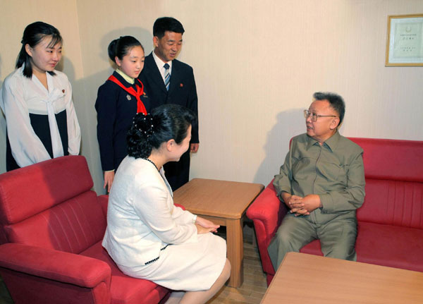 Leader of Democratic People&apos;s Republic of Korea (DPRK),Kim Jong-il (R) talks with family members of an artist (front), who newly joined the State Theatre, during Kim&apos;s visit to the artist&apos;s flat in Pyongyang in this picture released by the DPRK&apos;s KCNA news agency on Oct 9, 2010. [China Daily/Agencies]