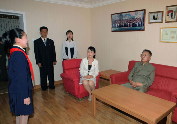 Leader of Democratic People&apos;s Republic of Korea (DPRK),Kim Jong-il (R) looks as a family member of an artist (2nd R), who newly joined the State Theatre, performs during Kim&apos;s visit to the artist&apos;s flat in Pyongyang in this picture released by the DPRK&apos;s KCNA news agency on Oct 9, 2010.[China Daily/Agencies] 