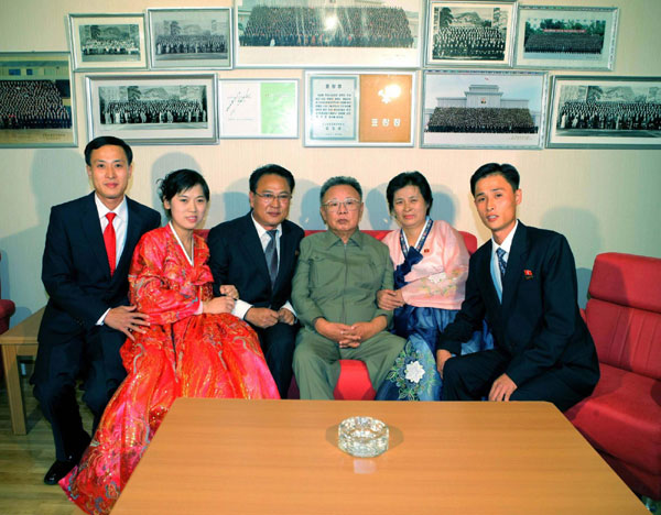 Leader of Democratic People&apos;s Republic of Korea (DPRK), Kim Jong-il (3rd R) poses with family members of an artist, who newly joined the State Theatre, in the artist&apos;s flat in Pyongyang in this picture released by the DPRK&apos;s KCNA news agency on Oct 9, 2010. [China Daily/Agencies]