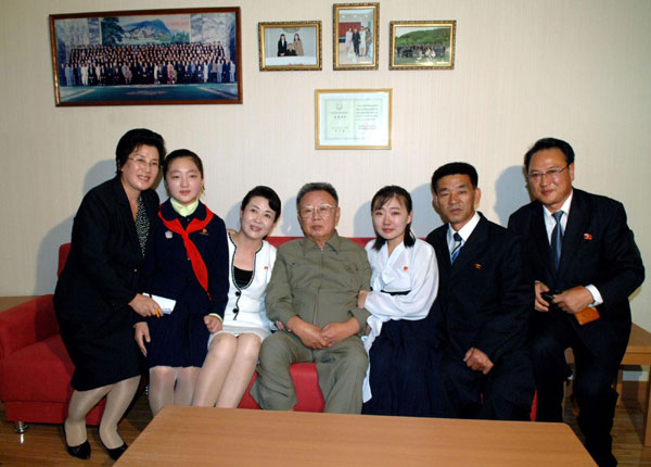 Leader of Democratic People&apos;s Republic of Korea (DPRK),Kim Jong-il (C) poses with family members of an artist, who newly joined the State Theatre, as the leader visits the artist&apos;s flat in Pyongyang in this picture released by the DPRK&apos;s KCNA news agency on Oct 9, 2010. [China Daily/Agencies]