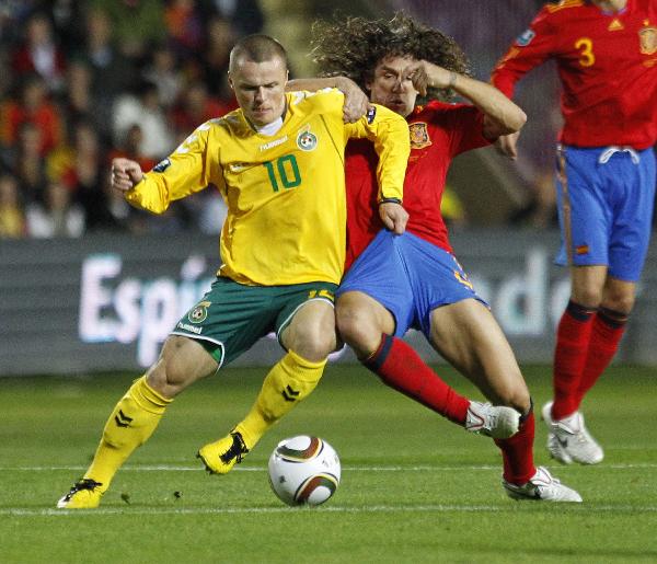 Lithuania's Darvydas Sernas (L) challenges Spain's Carles Puyol(C) during their Euro 2012 qualifying soccer match at the Helmantico stadium in Salamanca, October 8, 2010. World champion Spain beat Lithuania 3-1. (Xinhua/AFP Photo) 