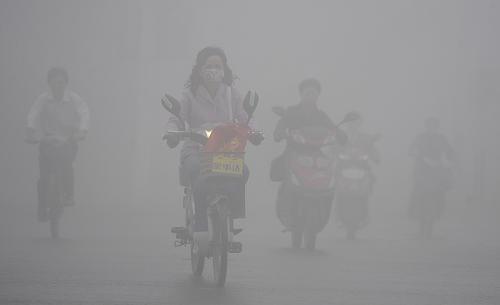 People ride bicycle in heavy fog in Hefei, east China&apos;s Anhui Province, Oct. 9, 2010. [Xinhua]