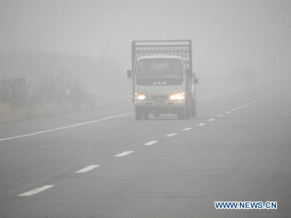 A truck runs in heavy fog in Tongliao, north China&apos;s Inner Mongolia Autonomous Region, Oct. 9, 2010. [Xinhua]