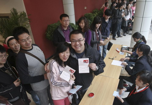 A couple shows off their marriage certificate at a registration bureau in Beijing, on Sunday Oct 10, 2010. [Xinhua] 