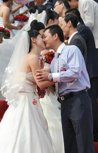 Couples exchange kisses at a group wedding ceremony in Jinan city, East China&apos;s Shandong province, on Sunday Oct 10, 2010. [Xinhua] 