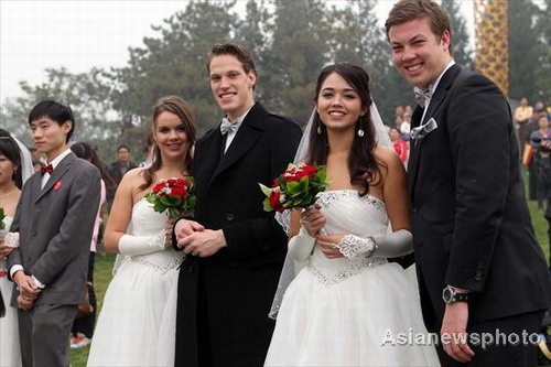 Couples pose for photos at a group wedding ceremony near the Bird&apos;s Nest (not pictured), the main stadium of the Beijing 2008 Olympic Games on Sunday Oct 10, 2010. [China Daily/Asianewsphoto]