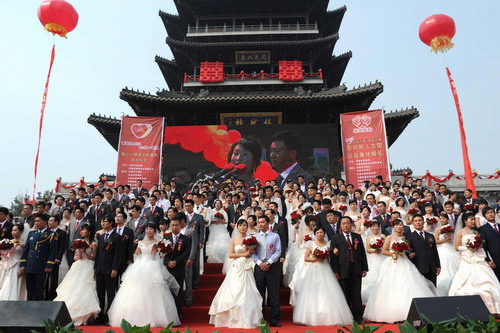 Couples pose for photos at a group wedding ceremony near the Bird&apos;s Nest (not pictured), the main stadium of the Beijing 2008 Olympic Games on Sunday Oct 10, 2010. [China Daily/Asianewsphoto]