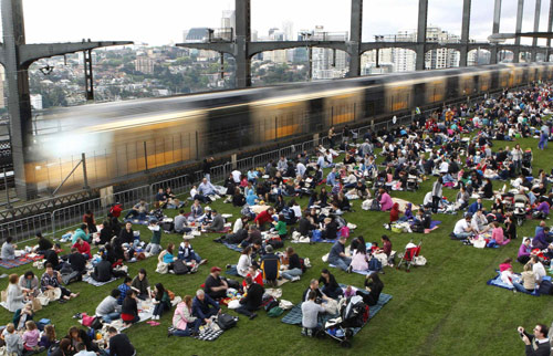 People picnic and take breakfast on the main deck of the Sydney Harbour Bridge during the Breakfast on the Bridge event in central Sydney Oct 10, 2010. More than 7,000 people gathered to picnic and have breakfast on the bridge. [China Daily/Agencies]