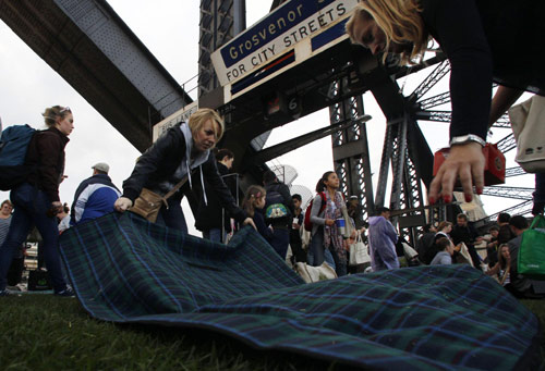 Picnickers lay down a blanket before having breakfast on the main deck of the Sydney Harbour Bridge during the Breakfast on the Bridge event in central Sydney Oct 10, 2010. [China Daily/Agencies]
