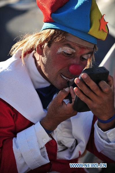 A clown makes up before he performs for relatives of the 33 trapped miners in San Jose mine, 800 km north of the Chilean capital Santiago, on Oct. 9, 2010. [Xinhua]