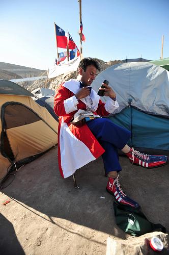 A clown makes up before he performs for relatives of the 33 trapped miners in San Jose mine, 800 km north of the Chilean capital Santiago, on Oct. 9, 2010. [Xinhua]