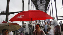 People picnic and have breakfast on the main deck of the Sydney Harbour Bridge as it rains during the Breakfast on the Bridge event in central Sydney October 10, 2010.