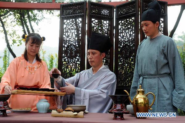 Artists from the China National Tea Museum perform tea art at an activity in Hangzhou, capital of east China's Zhejiang Province, Oct. 10, 2010. Tea artists from China, South Korea and Japan gathered in Hangzhou Sunday to exchange tea cultures.