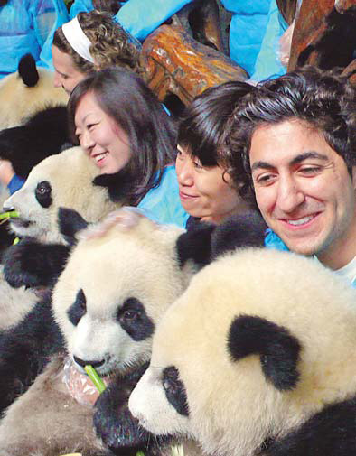 'Pambassadors' hug pandas in Chengdu after winning the Project Panda competition in this file photo taken on Sept 28. [China Daily] 