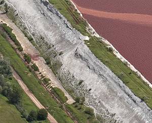 A June 2010 aerial photograph of the wall of the Kolontar sludge reservoir clearly shows damage and leakage - three months before dam walls breached, killing seven, covering 40 sq km with toxic red sludge and sending a plume of caustic pollution down rivers into the Danube. [WWF]