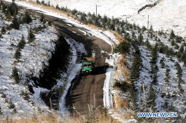 A truck travels on roads circled the Moon Mountain after snow in Yinchuan, capital of northwest China&apos;s Ningxia Hui Autonomous Region, Oct. 11, 2010. 