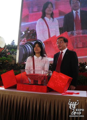  Qian Zhiguang (R), the deputy director of China Pavilion, gives the lucky visitor a 10-kilogram model of the pavilion. 