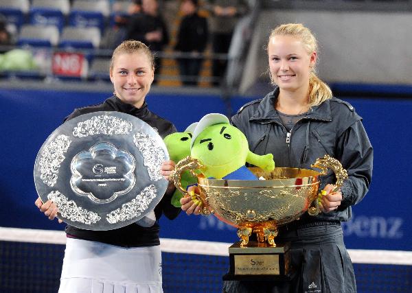 The winner Caroline Wozniacki (R) of Denmark and Vera Zvonareva of Russia pose with their trophies during the awarding ceremony after their final of women&apos;s singles in 2010 China Tennis Open Tournament at Lotus Court in National Tennis Center in Beijing, capital of China, Oct. 11, 2010. Wozniacki won 2-1 and claimed the title of the event. [Xinhua] 