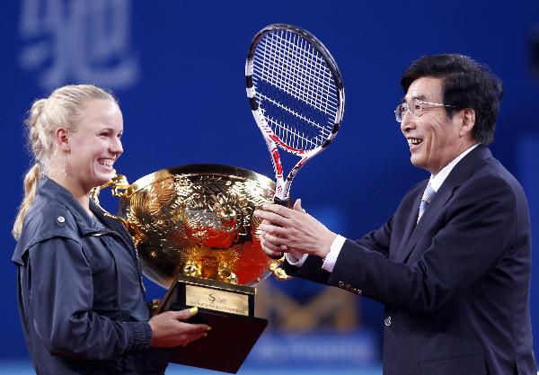 Caroline Wozniacki(L) of Denmark gives her tennis racket to Guo Jinlong, the mayor of Beijing during the awarding ceremony after her final of women&apos;s singles against Vera Zvonareva of Russia in 2010 China Tennis Open Tournament at Lotus Court in National Tennis Center in Beijing, capital of China, Oct. 11, 2010. Wozniacki won 2-1 and claimed the title of the event. [Xinhua] 