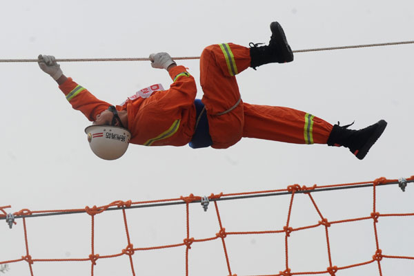 A fireman climbs a rope during a high-altitude salvage competition, Oct 10, 2010. [Xinhua]