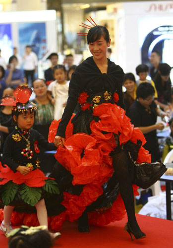 A mother and daughter model renovated clothes on stage during a DIY fashion show in Ningbo, East China&apos;s Zhejiang province on Sunday. More than 100 children and their parents participated to show off their fashion using old clothes, aiming to raise awareness of a low-carbon, environmentally friendly lifestyle. [Xinhua] 