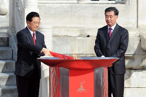 Chinese President Hu Jintao(L) lights the torch during the torch lighting ceremony of the 2010 Guangzhou Asian Games at the Temple of Heaven in Beijing, Oct 12, 2010. [Xinhua]