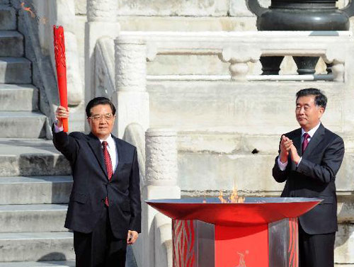 Chinese President Hu Jintao(L) raises the Guangzhou Asian Games torch during the torch lighting ceremony at the Temple of Heaven in Beijing, Oct 12, 2010. [Xinhua] 