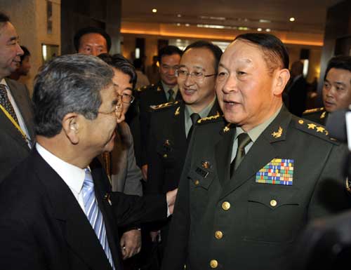 China's Defence Minister Liang Guanglie (right) speaks with Japan's Defence Minister Toshimi Kitazawa in Hanoi on Monday. [Xinhua]