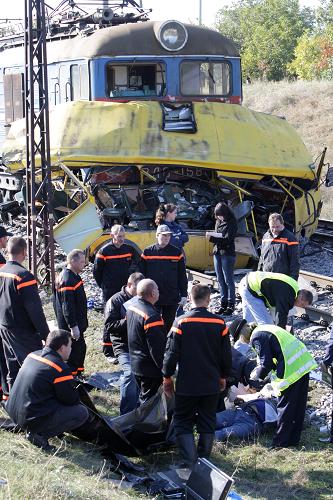 Investigators stand next to the wreckage of a bus after a collision in Ukraine&apos;s Dnipropetrovsk region October 12, 2010. [Xinhua] 