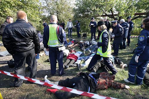 Police officers stand next to the wreckage of a bus after a collision in Ukraine&apos;s Dnipropetrovsk region October 12, 2010. [Xinhua] 