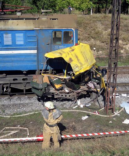 A firefighter stands near the wreckage of a bus and the covered bodies of victims (R) after a collision in Ukraine&apos;s Dnipropetrovsk region October 12, 2010. [Xinhua]