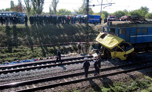 Police officers stand next to the wreckage of a bus after a collision in Ukraine&apos;s Dnipropetrovsk region October 12, 2010. [Xinhua] 