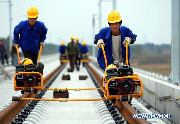 Workers fix up railway track on Beijing-Shanghai High-Speed Railway in Cangzhou City, east China&apos;s Hebei Province, Oct. 12, 2010. The track laying operation of Beijing-Shanghai High-Speed Railway will be completed by the end of this October. [Xinhua] 