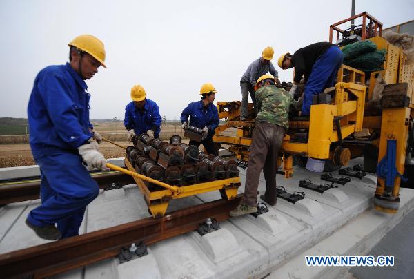 Workers lay the railway track on Beijing-Shanghai High-Speed Railway in Cangzhou City, east China&apos;s Hebei Province, Oct. 12, 2010. The track laying operation of Beijing-Shanghai High-Speed Railway will be completed by the end of this October. [Xinhua]