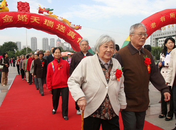 Couples walk on the red carpet during a celebration of their golden jubilee wedding anniversary ahead of the Double Ninth Festival in Jinan, East China&apos;s Shandong province, Oct 12, 2010. A total of 100 couples, married for 50 years, attended the party to embrace the upcoming festival, which is for the elderly and falls on the ninth day of the ninth month in the Chinese lunar calendar, Oct 16 this year. [Xinhua]