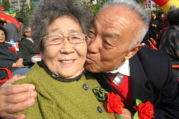  A man kisses his wife during a celebration of their golden jubilee wedding anniversary ahead of the Double Ninth Festival in Jinan, East China&apos;s Shandong province, Oct 12, 2010. [Xinhua]