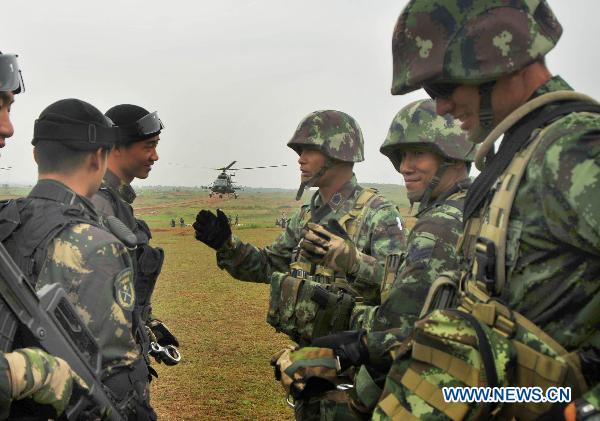 Chinese and Thai soldiers encourage each other in Guilin, southwest China&apos;s Guangxi Zhuang Autonomous Region, on Oct. 12, 2010. The &apos;Strike-2010&apos; joint anti-terrorism drill held by Chinese and Thai special forces launched an airlanding practice Tuesday. [Huang Shuo/Xinhua]