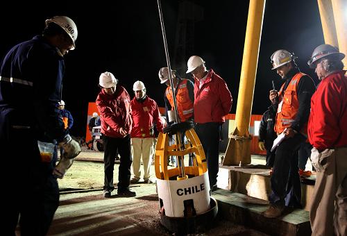 Chilean President Sebastian Pinera (C, looking down) stays with workers to start the rescue operation at the San Jose mine, in Copiapo, Chile, October 12, 2010. [Xinhua] 