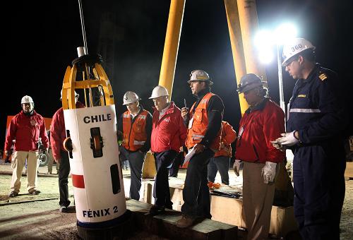 Chilean President Sebastian Pinera (C, looking down) stays with workers to start the rescue operation at the San Jose mine, in Copiapo, Chile, October 12, 2010. [Xinhua] 
