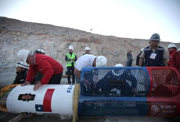 In this image released by the government of Chile, Minister of Health Jaime Mañalich (C) oversees final details of the capsule Phoenix 2 that will be used to rescue the 33 trapped miners at the San Jose copper mine, in northern Chile, on Oct. 12, 2010. [Xinhua/Government of Chile] 