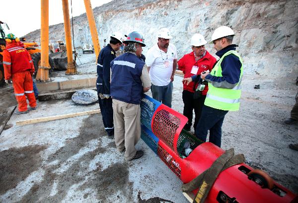 In this image released by the government of Chile, Minister of Health Jaime Mañalich (2nd R) oversees final details of the capsule Phoenix 2 that will be used to rescue the 33 trapped miners at the San Jose copper mine, in northern Chile, on Oct. 12, 2010. [Xinhua/Government of Chile]