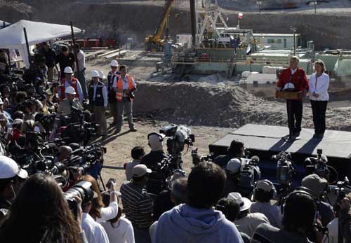 Chilean President Sebastian Pinera (red jacket) and his wife Cecilia Morel give a press conference before the start of the operation to rescue the 33 trapped miners at the San Jose mine in Copiapo Oct 12, 2010. [China Daily/Agencies]