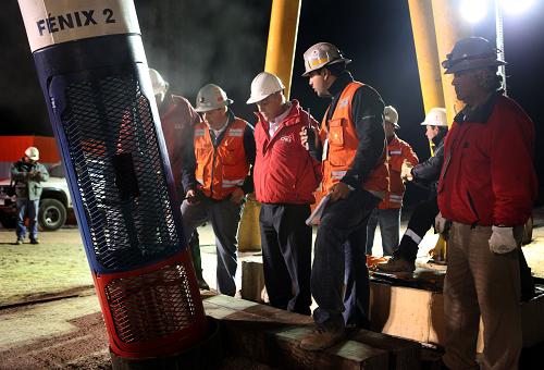 Chilean President Sebastian Pinera (C, looking down) stays with workers to start the rescue operation at the San Jose mine, in Copiapo, Chile, October 12, 2010. [Xinhua] 