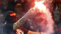 A supporter of Serbia's soccer team holds a lit flare before the team's Euro 2012 qualifying soccer match against Italy at the Luigi Ferraris stadium in Genoa October 12, 2010.