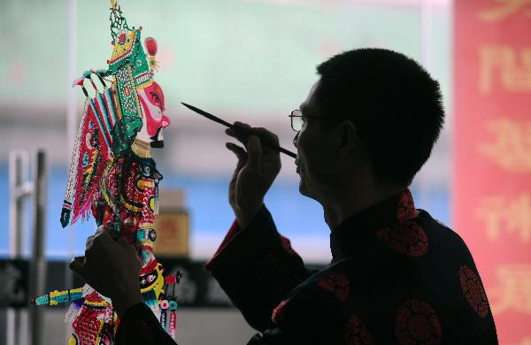He Zehua colors a shadow play puppet in his museum in Shuidong Town, Xuancheng City of east China's Anhui Province, Oct. 12, 2010.