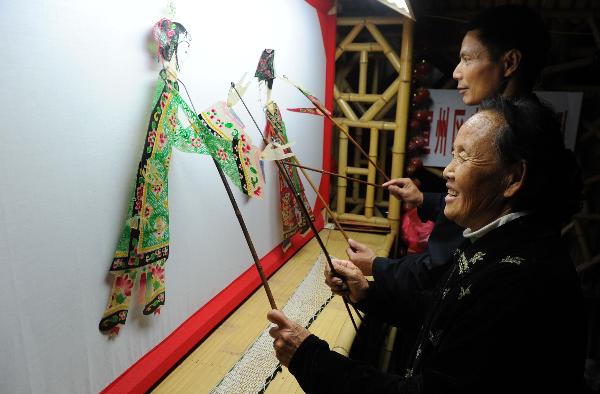 He Zehua (top) and Ke Yuying perform shadow play in He's museum in Shuidong Town, Xuancheng City of east China's Anhui Province, Oct. 12, 2010.