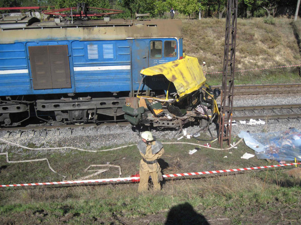 A firefighter stands near the wreckage of a bus and the covered bodies of victims (R) after a collision in Ukraine's Dnipropetrovsk region October 12, 2010. [Photo/Agencies] 