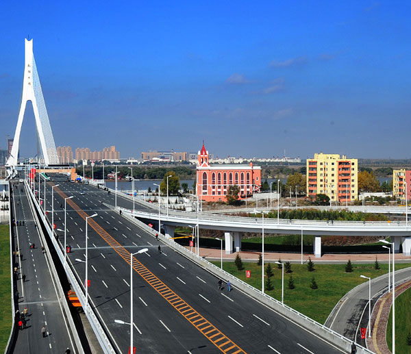 An aerial view shows the newly built Songpu Bridge in Harbin, capital of Northeast China&apos;s Heilongjiang province, Oct 12, 2010. The 4-kilometer bridge, spanning the Songhua River, was opened to traffic on Wednesday. The eight-lane bridge, a 5-minute crossing, can carry up to 9,800 vehicles during peak hours. The new bridge will mitigate the traffic pressure on the river and help promote prosperity on both sides. [Xinhua]