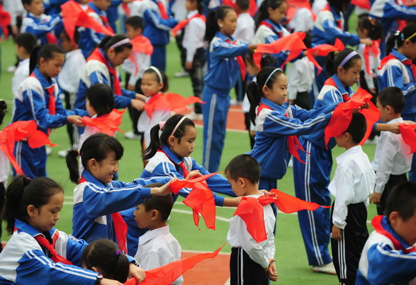 A staggering 400,000 children from more than 10,000 schools join the Young Pioneer League of China, with red scarves put on by league members from higher grades in an initiation ceremony in Taiyuan, capital of Shanxi province, Oct 12, 2010. [Xinhua]